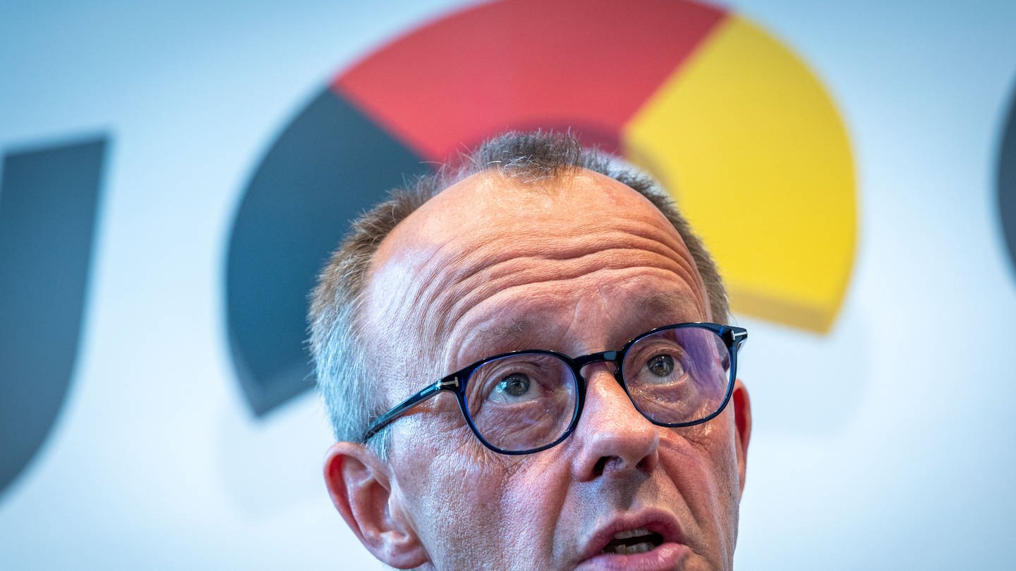 CDU-Chef Friedrich Merz, über seinem Kopf -bogenförmig- die Deutschlandfarben Scwharz, Rot und Gold (Foto: dpa Bildfunk, picture alliance/ dpa/ Jens Büttner)