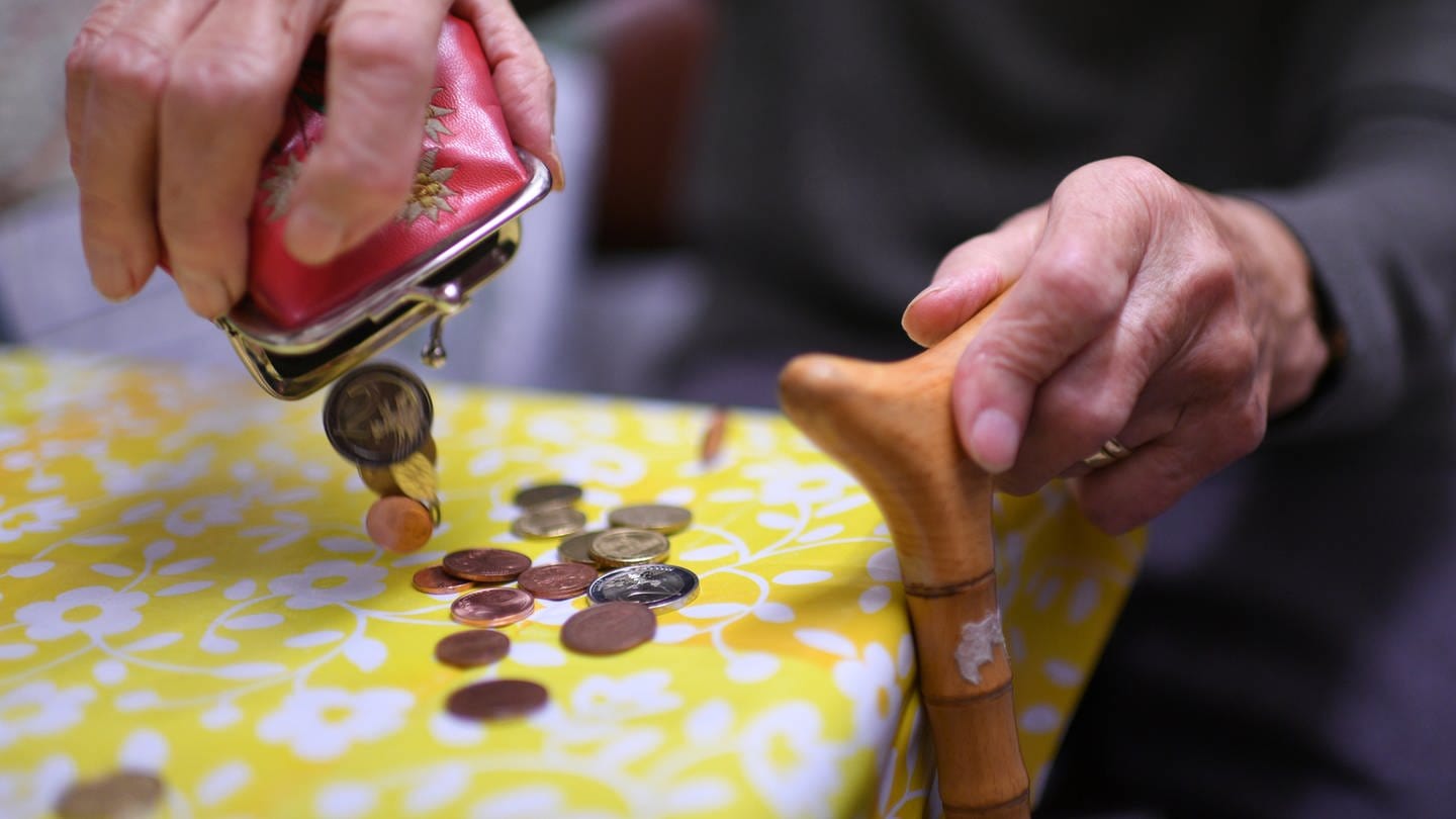 Eine alte Frau leert ihren Geldbeutel auf dem Küchentisch aus (Foto: dpa Bildfunk, picture alliance/dpa | Felix Kästle)