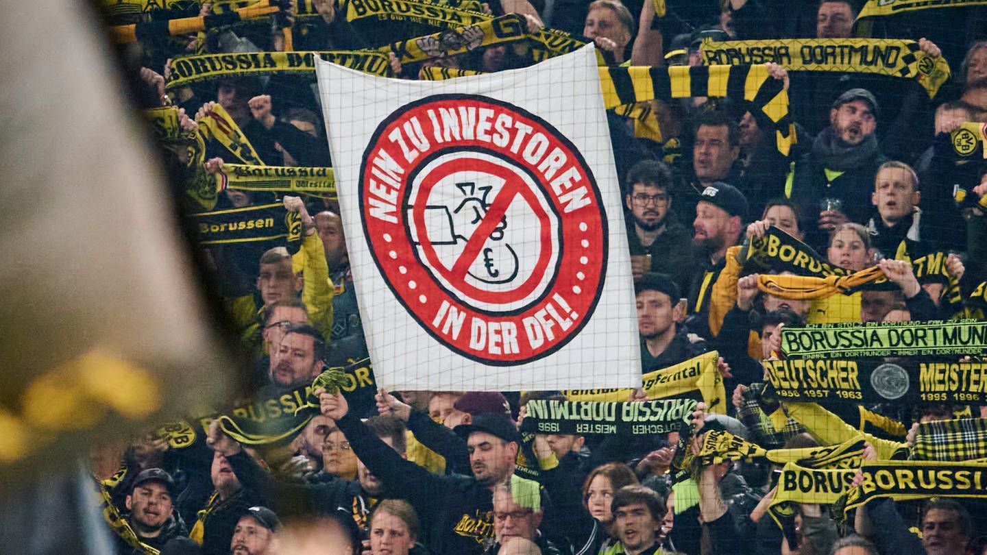 BVB-Fans halten ein Banner mit dem Schriftzug 