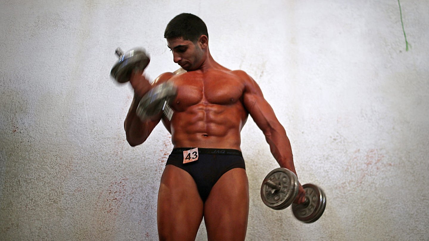 Bodybuilder mit Gewichten an den Händen (Foto: dpa Bildfunk, picture alliance / dpa | Mohammed Saber)