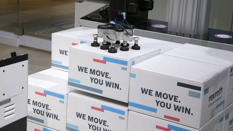 Kartons werden mit einem Roboter gestapelt. (Foto: IMAGO, IMAGO / Cord)