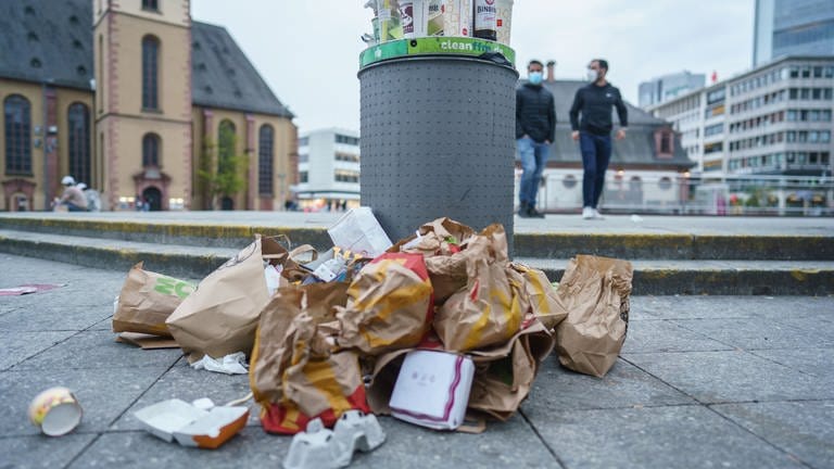 Müll liegt in der Innenstadt neben einem überfüllten Abfallbehälter (Foto: dpa Bildfunk, picture alliance/dpa | Frank Rumpenhorst)