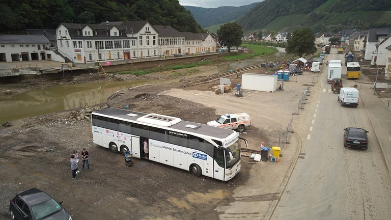 Ein weißer, umgebauter Reisebus steht im von der Flut zerstörten Dernau. Betroffene können dort psychologische Beratung bekommen. (Foto: dpa Bildfunk, Picture Alliance)