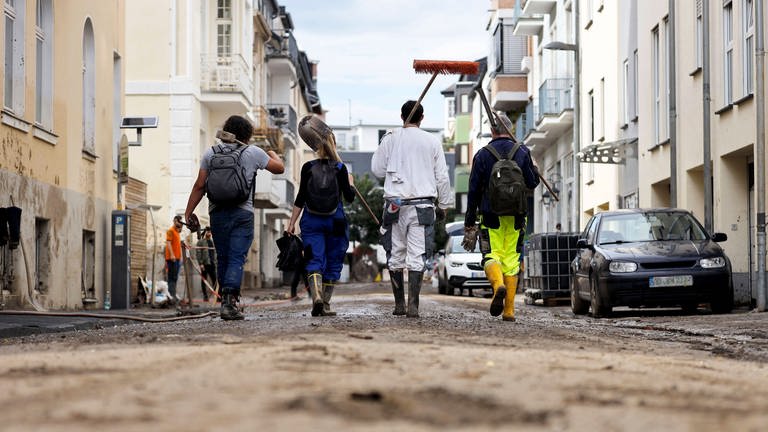 Nach dem Jahrhunderthochwasser im Ahrtal haben die Aufräumarbeiten Fortschritte gemacht. Viele Freiwillige helfen dabei, Straßen zu räumen und Schutt und Schlamm zu entfernen, wie hier in Bad Neuenahr. (Foto: IMAGO, IMAGO / Future Image)