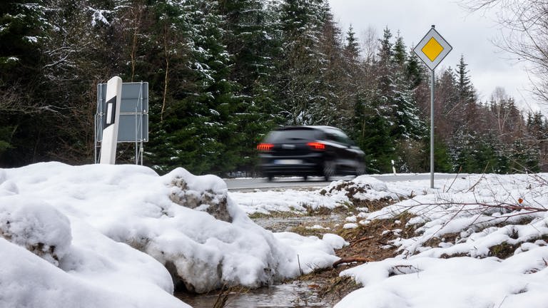 Ein Auto fährt durch eine verschneite Landschaft. (Foto: dpa Bildfunk, Picture Alliance)