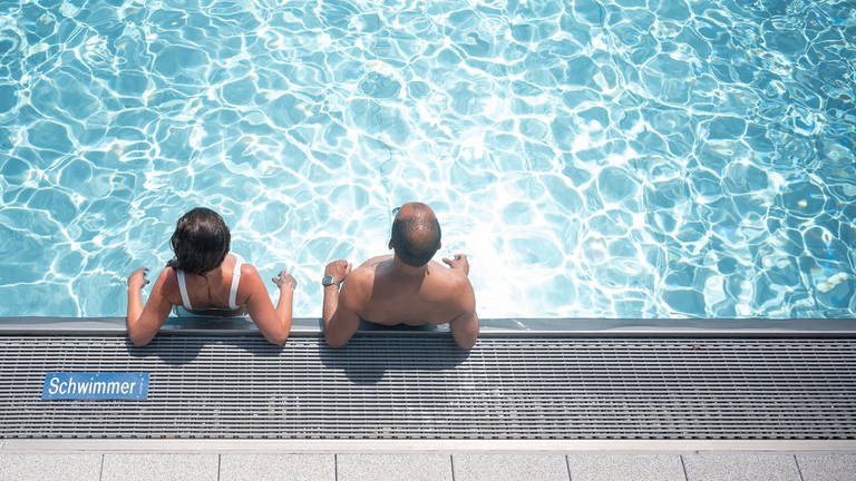 Zwei Badegäste stehen am Rand eines Schwimmbeckens. (Foto: dpa Bildfunk, picture alliance/dpa | Sebastian Gollnow)