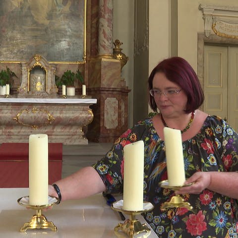Altkatholische Pfarrerin stellt Kerzen in ihrer Kirche auf (Foto: SWR, SWR)