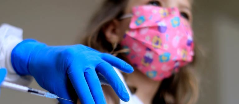 Kind mit Mundschutz wird während der Corona-Pandemie geimpft (Foto: dpa Bildfunk, picture alliance / Laci Perenyi | Laci Perenyi)