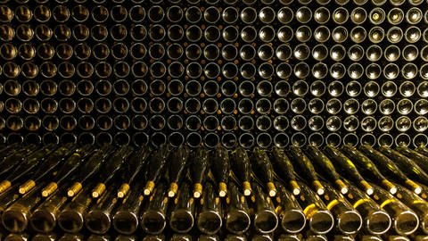 Viele Weinflaschen liegen gestapel übereinander. Noch haben sie keine Etiketten. Im EU-Parlament gibt es Überlegungen, Warnhinweise auf Weinflaschen und anderen alkoholischen Getränken einzuführen. (Foto: dpa Bildfunk, picture alliance/dpa | Philipp von Ditfurth)
