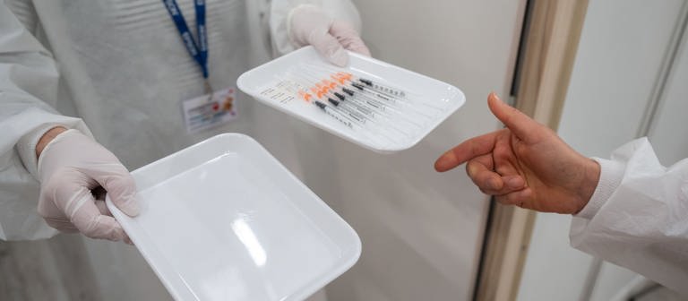 Eine Krankenschwester nimmt im Impfzentrum in der Paul-Horn-Arena sechs Spritzen mit Covid-19 Impfstoff von BiontechPfizer, die aus einer einzelnen Ampulle zubereitet wurden, entgegen. (Foto: dpa Bildfunk, picture alliance/dpa | Marijan Murat)