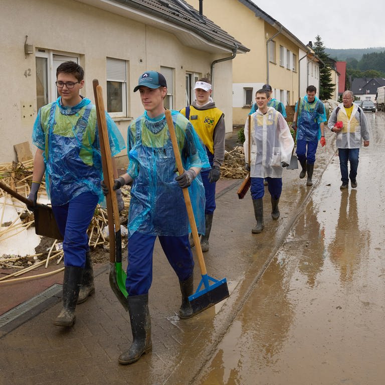 Eine Gruppe von Helfern aus den USA wechselt im strömenden Regen den Einsatzort. 