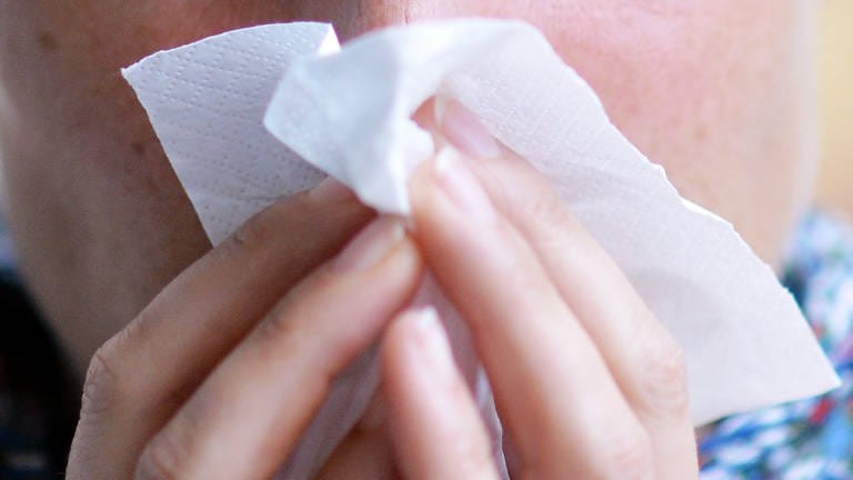 Eine Frau putzt sich die Nase mit einem Papiertaschentuch (Foto: dpa Bildfunk, picture alliance/dpa | Maurizio Gambarini)
