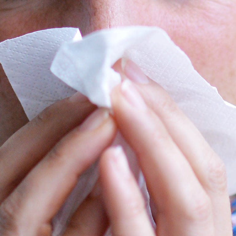 Eine Frau putzt sich die Nase mit einem Papiertaschentuch (Foto: dpa Bildfunk, picture alliance/dpa | Maurizio Gambarini)