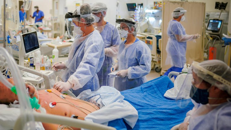 Ein Covid-19-Patient wird auf einer Intensivstation von Ärzten und Pflegern untersucht (Symbolbild). (Foto: dpa Bildfunk, picture alliance/dpa/AP | Jefferson Bernardes)