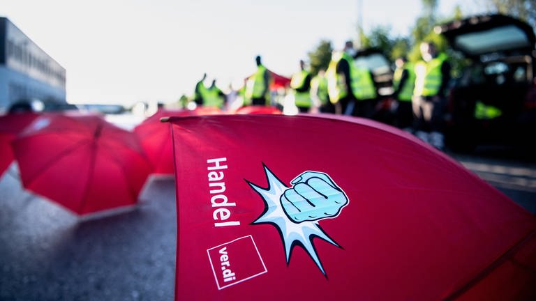 Rote Regenschirme mit dem Aufdruck "Handel. Verdi" In Rheinland-Pfalz organisiert die Gewerkschaft Verdi erste Warnstreiks im Versand- und Einzelhandel. (Foto: dpa Bildfunk, picture alliance/dpa | Matthias Balk)