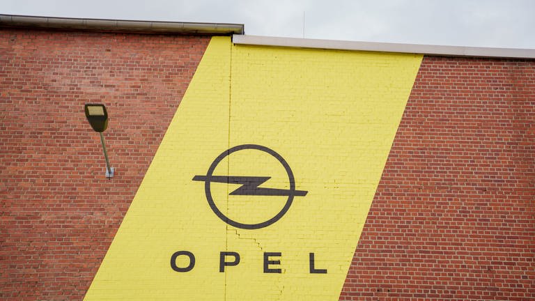 Das Opel-Logo steht auf einer Fassade des Opel-Werks. (Foto: dpa Bildfunk, picture alliance/dpa | Andreas Arnold)