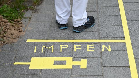 Schriftzug "Impfen" auf einem Bürgersteig mit einer gezeichneten Spritze (Foto: picture-alliance / Reportdienste, Picture Alliance)