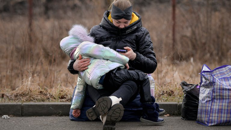 Eine Frau, die vor dem Konflikt in der benachbarten Ukraine geflohen ist, wartet mit ihrem Kind an der rumänisch-ukrainischen Grenze auf ein Transportmittel. Wegen des russischen Angriffs auf die Ukraine sind nach Angaben des UN-Flüchtlingshilfswerks (UNHCR) etwa 368.000 Menschen auf der Flucht. (Foto: dpa Bildfunk, Picture Alliance)