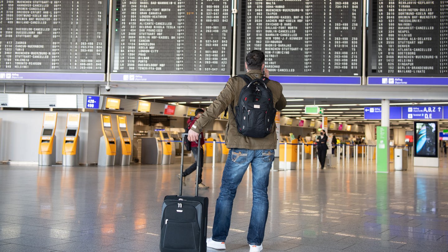 Ein Mann steht mit seinem Gepäck im nahezu menschenleeren Terminal 1 des Flughafens Frankfurt. (Foto: dpa Bildfunk, picture alliance/dpa | Boris Roessler)
