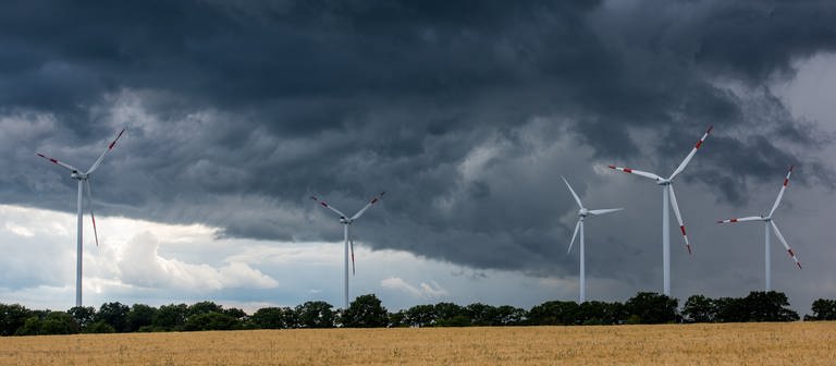 Dunkle Wolken türmen sich über Windrädern auf: Ab Dienstag sind in Rheinland-Pfalz erneut Gewitter mit Starkregen und Sturmböen angekündigt (Symbolbild). (Foto: picture-alliance / Reportdienste, picture alliance / dpa | Patrick Pleul)
