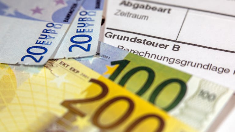 Geldscheine liegen auf einem Grundsteuer-Abgabenbescheid (Foto: picture-alliance / Reportdienste, picture alliance/dpa | Jens Büttner)