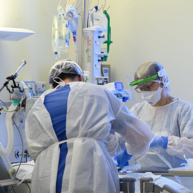 Zwei Intensivpflegerinnen sind mit der Versorgung eines Corona-Patienten beschäftigt. (Foto: picture-alliance / Reportdienste, picture alliance/dpa/dpa-Zentralbild | Robert Michael)