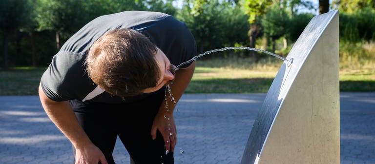 Ein Sportler trinkt Wasser an einem öffentlichen Trinkwasserspender der Stadt Hannover.  (Foto: dpa Bildfunk, picture alliance/dpa | Julian Stratenschulte)
