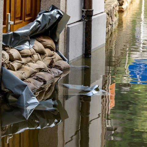 Sandsäcke vor einem Hauseingang in einer überfluteten Straße (Foto: dpa Bildfunk, picture alliance/dpa | Armin Weigel)
