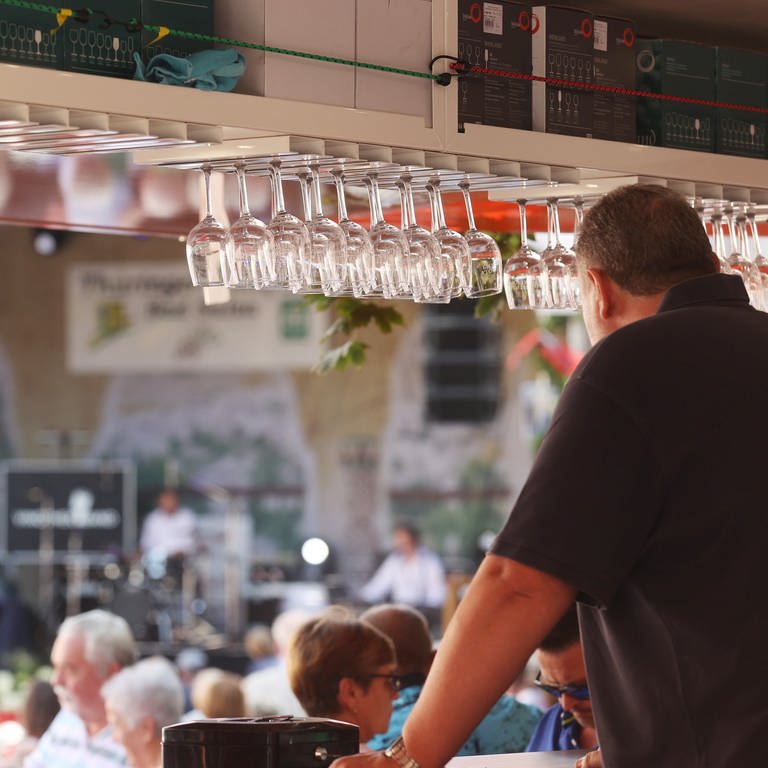 Mann steht an einem Weinstand, Gläser hängen vor ihm  (Foto: dpa Bildfunk, picture alliance/dpa | Bodo Schackow)