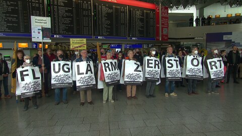 Fluglärm-Gegener formieren sich am Flughafen Frankfurt und bilden mit ihren Schildern den Satz: Fluglärm zerstört.  (Foto: SWR)