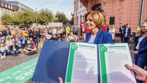 Klimaaktivisten übergeben eine Mappe mit Forderungen an Ministerpräsidentin Malu Dreyer (SPD). (Foto: dpa Bildfunk, picture alliance/dpa | Andreas Arnold)