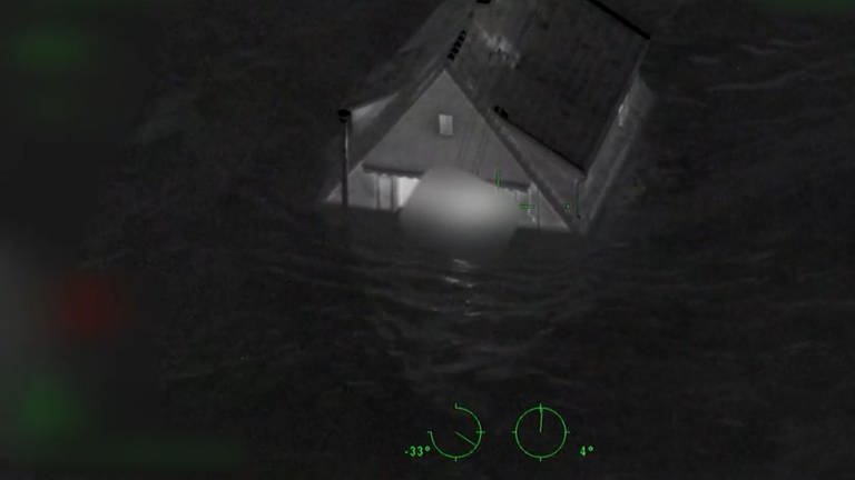 Ein Haus inmitten der Wassermassen, die in der Nacht des 14. Juli das Ahrtal überflutet haben. In einem Stockwerk brennt noch Licht. Das Innenministerium hat die Aufnahmen, die ein Polizeihubschrauber aufgenommen hatte, nun erstmals veröffentlicht. (Foto: Polizei Rheinland-Pfalz)