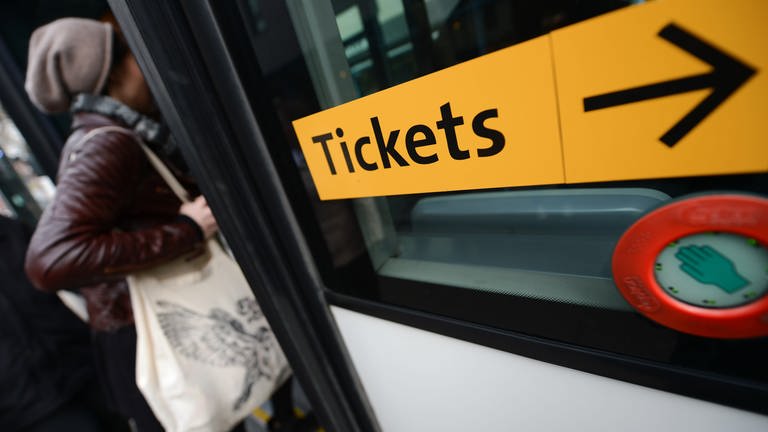 Ein Aufkleber mit der Aufschrift "Tickets" ist an einem Bus angebracht.  (Foto: picture-alliance / Reportdienste, Arne Dedert/dpa)