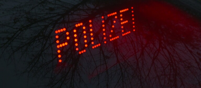 In roten Leuchtbuchstaben steht das Wort Polizei vor dunklem Hintergrund geschrieben (Foto: SWR)