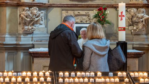 Besucher stehen im Trierer Dom vor einem Bild des an Silvester verstorbenen, emeritierten Papstes Benedikt XVI. (Foto: picture-alliance / Reportdienste, picture alliance/dpa | Harald Tittel)