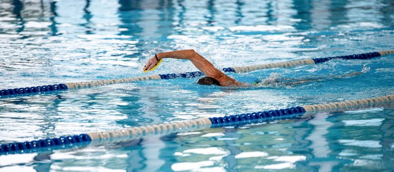 Ein Schwimmer im Hallenbad. In RLP erhöhen erste Bäder nach der Energiekrise wieder die Wassertemperatur. (Foto: dpa Bildfunk, picture alliance/dpa | Sina Schuldt)