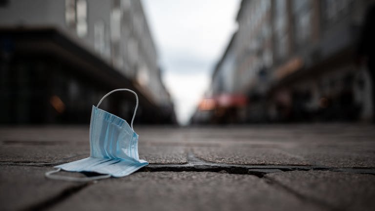 Eine Maske liegt auf dem Boden in der Innenstadt. (Foto: dpa Bildfunk, Picture Alliance)