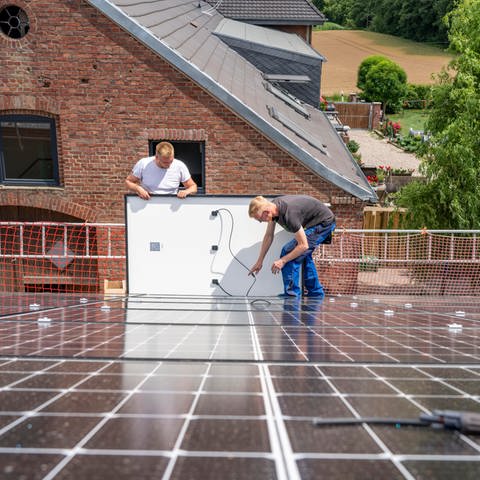Montage von Solarmodulen auf das Dach einer Scheune, eines landwirtschaftlichen Betriebs. (Foto: dpa Bildfunk, Picture Alliance)