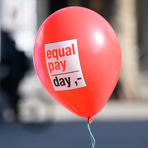 Ein Ballon mit Aufschrift „Equal Pay Day“ schwebt in der Luft. (Foto: picture-alliance / Reportdienste, picture alliance/dpa | Julian Stratenschulte)