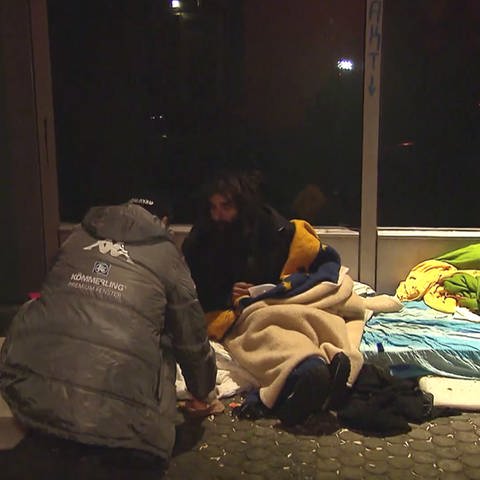 ein Sozialarbeiter unterhält sich mit einem Obdachlosen (Foto: SWR)