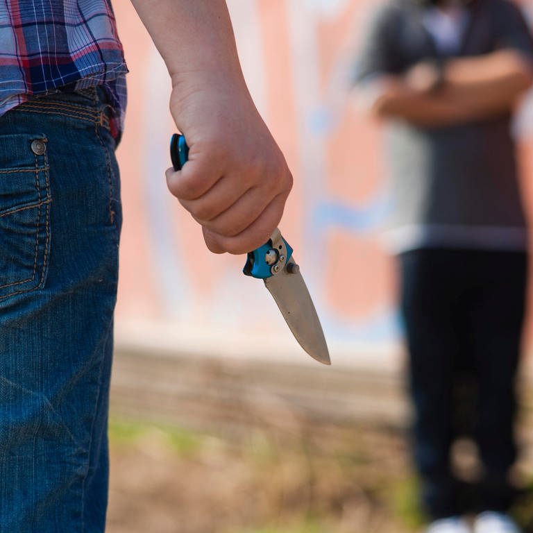 Ein Junge wird vor einem Jugendlichen mit einem Messer bedroht (Foto: dpa Bildfunk, Picture Alliance)