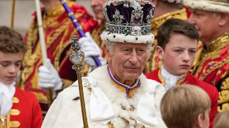 Großbritanniens König Charles III. verlässt nach der Krönungszeremonie mit der Imperial State Crown, einem Zepter und dem Reichsapfel die Westminster Abbey.  (Foto: dpa Bildfunk, picture alliance/dpa/AP | Alessandra Tarantino)