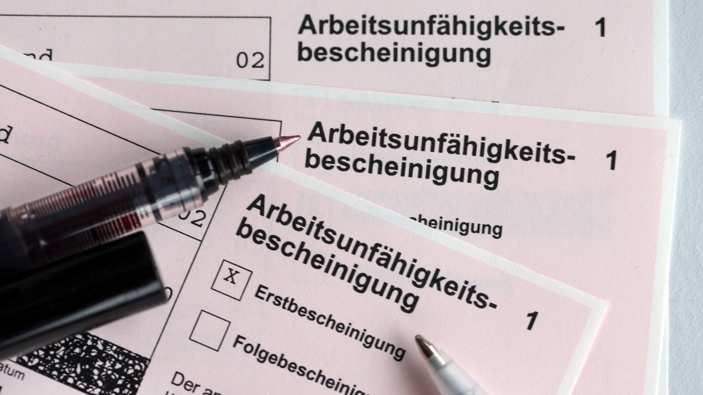 Stifte liegen auf den Arbeitsunfähigkeitsbescheinigungen für Arbeitnehmer im Falle einer Krankschreibung durch den Arzt (Foto: dpa Bildfunk, Jens Büttner)