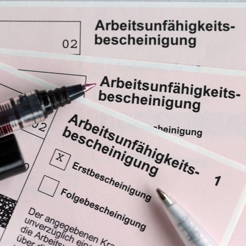 Stifte liegen auf den Arbeitsunfähigkeitsbescheinigungen für Arbeitnehmer im Falle einer Krankschreibung durch den Arzt (Foto: dpa Bildfunk, Jens Büttner)