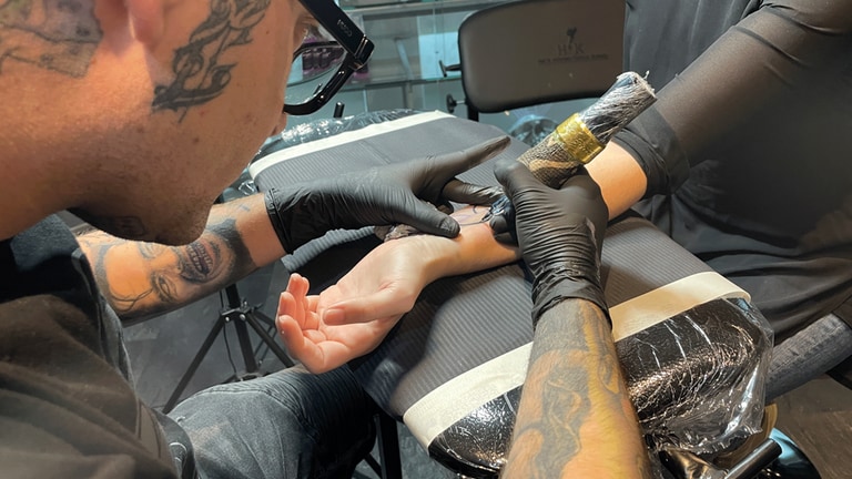 Ein Tattoo-Artist sticht seiner Kundin das Organspendetattoo. (Foto: SWR)