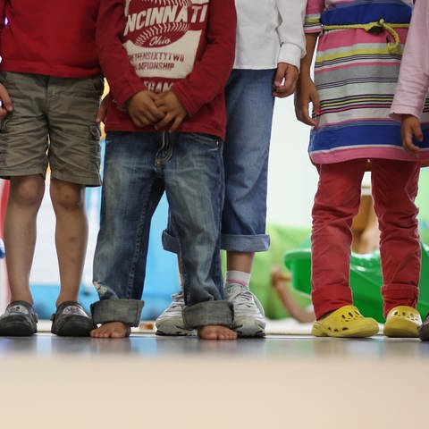 Mehrere Kinder stehen in einem Kindergarten nebeneinander (Foto: dpa Bildfunk, Picture Alliance)