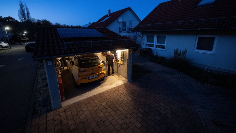 Ein Mann lädt in seiner Garage ein E-Auto mittels einer Wallbox.  (Foto: dpa Bildfunk, picture alliance/dpa | Marijan Murat)