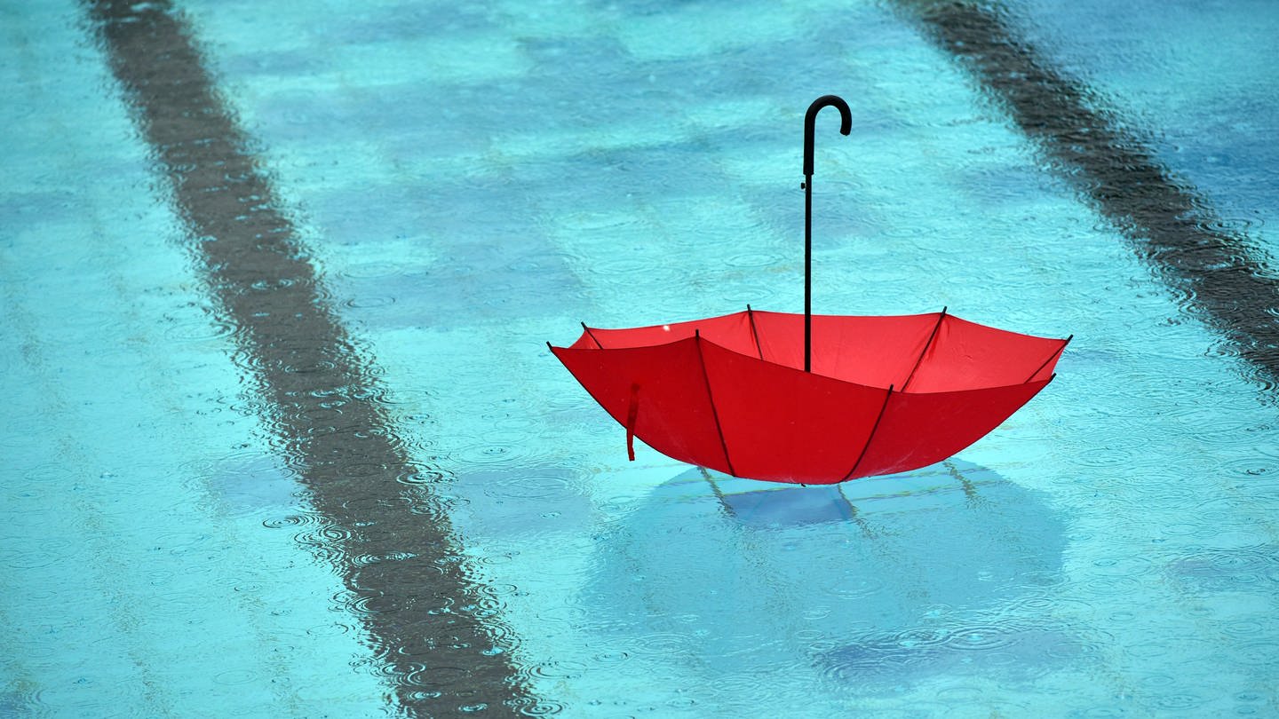 Man sieht einen roten Regenschirm im Freibad-Becken (Foto: dpa Bildfunk, picture alliance/dpa/dpa-Zentralbild | Ralf Hirschberger)