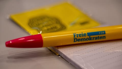 Ein FDP-Stift liegt auf einem Schreibblock. (Foto: dpa Bildfunk, Picture Alliance)