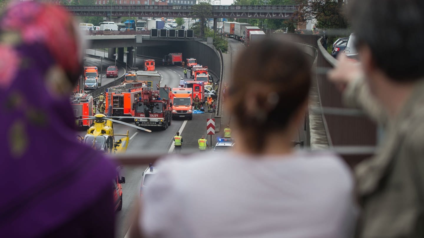 Schaulustige stehen am 15.05.2017 in Berlin auf dem Sachsendamm auf einer Brücke und beobachten einen Unfall. (Foto: dpa Bildfunk, picture alliance / Lino Mirgeler/dpa | Lino Mirgeler)
